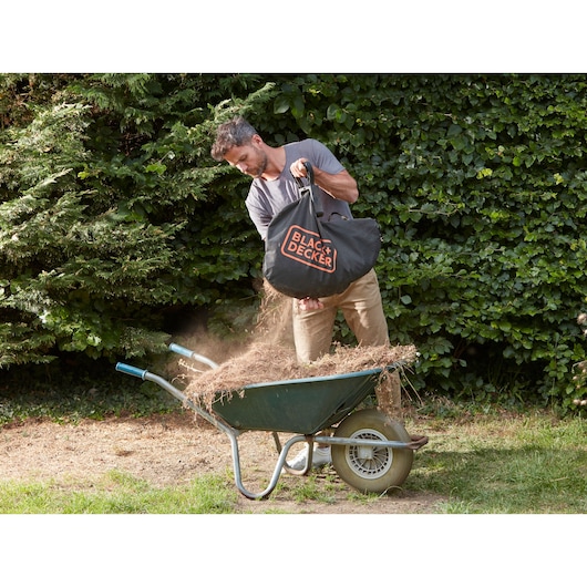 BLACK+DECKER BCBLV36B tuinstofzuigerzak wordt buiten in een kruiwagen geleegd.