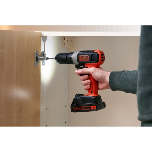 BLACKDECKER perceuse sans fil BCD001C2 avec LED, utilisée pour assembler un meuble. Photo en contexte.
