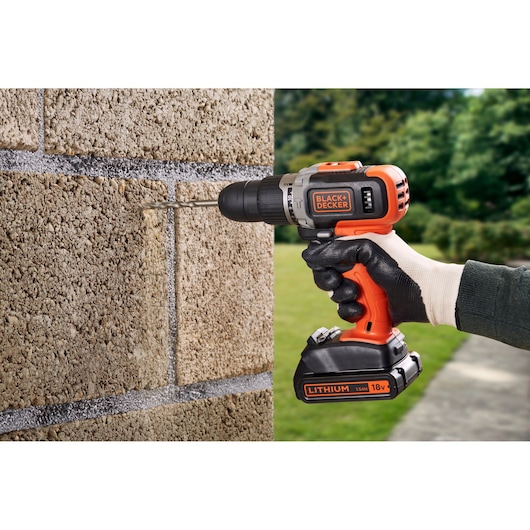 BLACKDECKER BCD003C2K perceuse sans fil utilisée pour percer un mur en briques à l'extérieur.