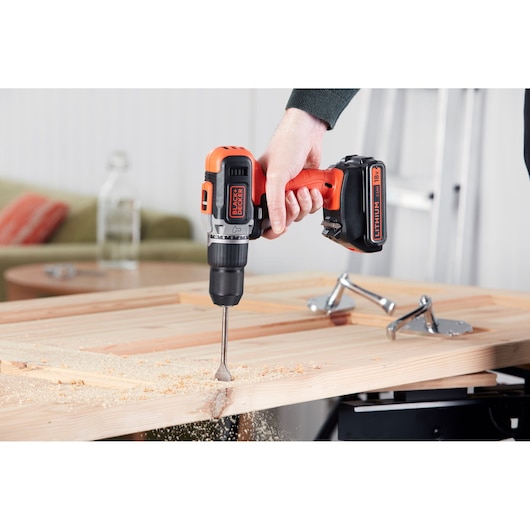 BLACKDECKER BCD003MEM2K perceuse sans fil utilisée pour percer du bois, photo en gros plan de l’outil.