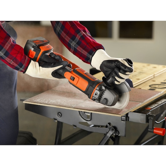 BLACKDECKER BCG720M1 draadloze haakse slijper gebruikt om tegels op werkbank te snijden.