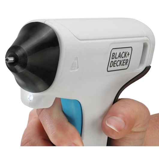 BLACK+DECKER BCGL115 witte draadloze lijmpistool zijaanzicht met LED-licht, vastgehouden in hand.