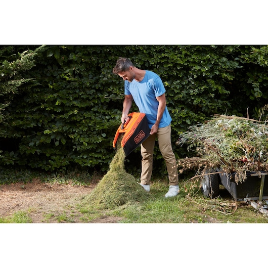 Photo de la boîte à herbe du broyeur BLACKDECKER BCMW33184L2 vidée à l’extérieur.