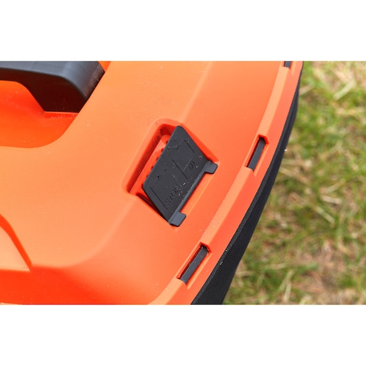Photo en gros plan du panneau de commande de la tondeuse BLACKDECKER BCMW33185L2 avec bouton d'arrêt noir sur corps orange.