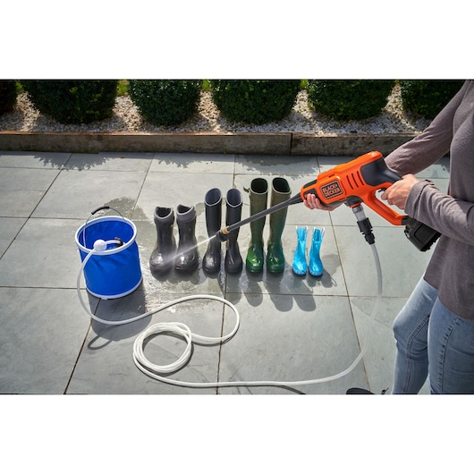 BLACKDECKER BCPC18B draagbare hogedrukreiniger maakt laarzen schoon buiten, zijaanzicht.