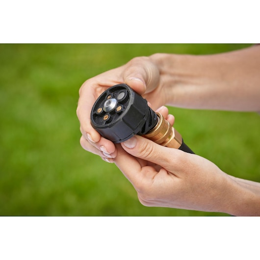 BLACKDECKER BCPC18D1 tuinslangmondstuk in hand gehouden, close-up buiten.