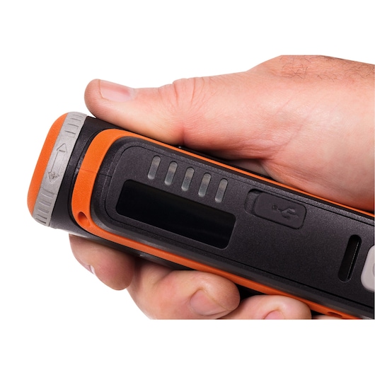 Close-up van BLACK+DECKER BCRT8IK draagbaar gereedschap met oranje en zwarte behuizing, LED-indicatoren en USB-poort in hand.