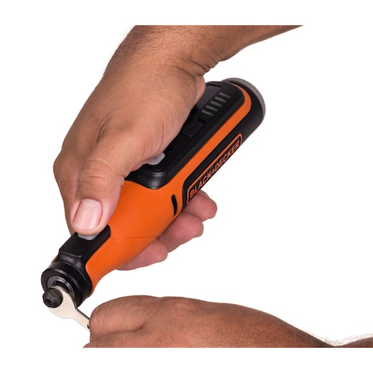 Foto van de oranje-zwarte BLACK+DECKER BCRT8IK roterende tool in gebruik, close-up van handen die het hulpmiddel bedienen.