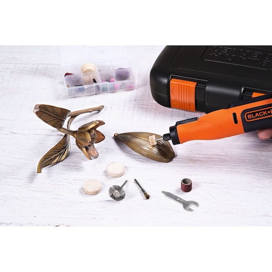 BLACK+DECKER BCRT8IK roterend gereedschap met accessoires poetst metalen bladsculptuur, zijaanzicht.