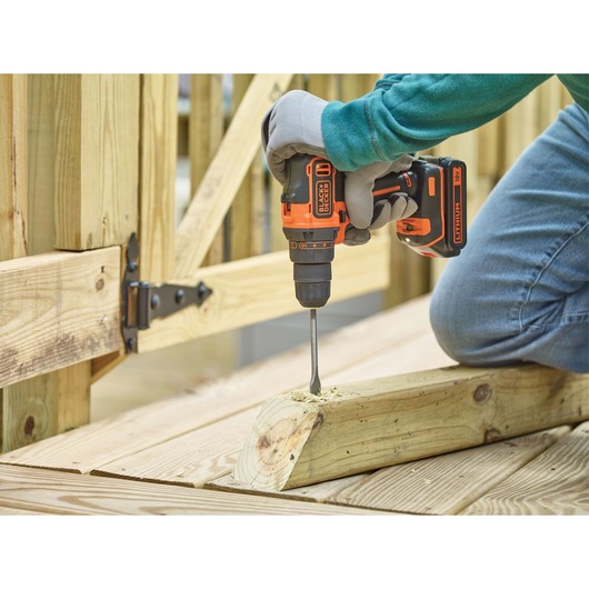 BLACKDECKER BDCDD186B perceuse sans fil utilisée pour percer une poutre en bois à l'extérieur.