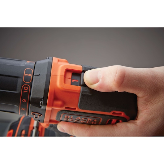 Photo en gros plan d'une main réglant la vitesse sur la perceuse sans fil BLACK+DECKER BDCHD18KB2, noir et orange.