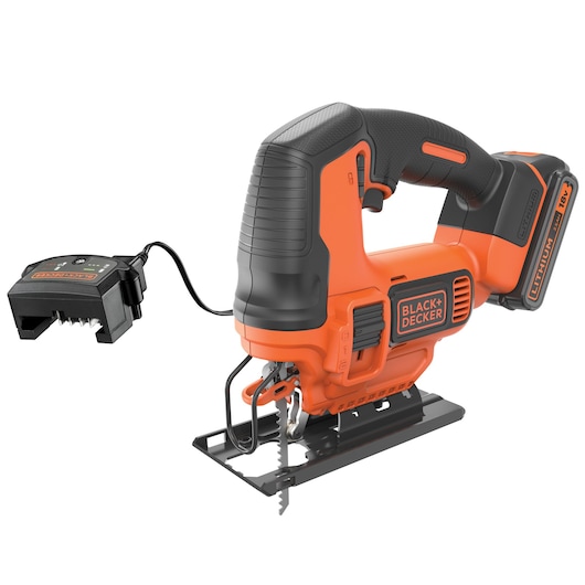 Een draadloze BLACK+DECKER decoupeerzaag met een oranje-zwart ontwerp, voorzien van een 18V lithiumbatterij en een aparte batterijoplader die met een kabel is aangesloten.