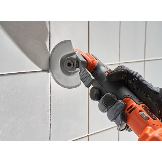 BLACK+DECKER BDCOS18N snoerloos multitool snijdt tegelspecie, close-up zijaanzicht.
