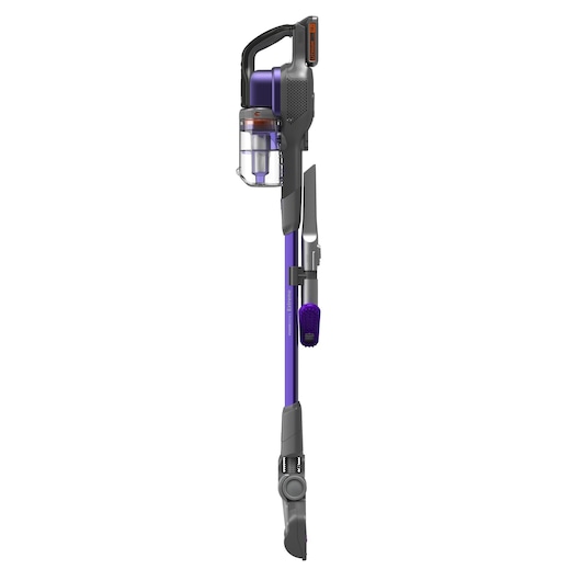 Un aspirateur balai sans fil BLACK+DECKER avec un design violet et gris. L'aspirateur possède un bac à poussière transparent et des accessoires de nettoyage attachés, dont une brosse et un embout pour les crevasses. Il est présenté debout sur un fond blanc.