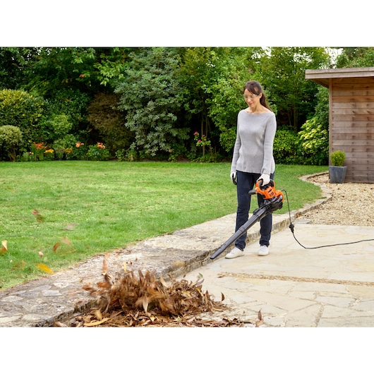 BLACKDECKER BEBLV301 bladblazer in gebruik buiten, blaast bladeren van terras, met snoer, fotografie.