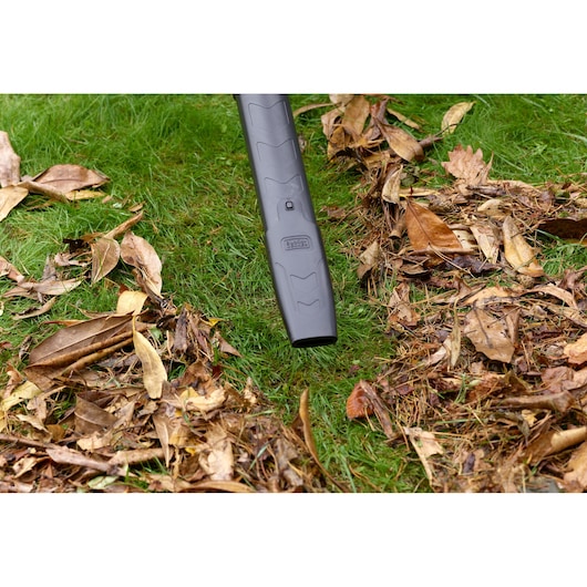 BLACKDECKER BEBLV301 bladblazer mondstuk verwijdert droge bladeren op gras, close-up buitenfotografie.