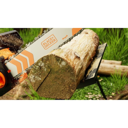 Foto van BLACK+DECKER BECS1835 kettingzaag die buiten een boomstam zaagt, oranje-witte geleider zichtbaar.