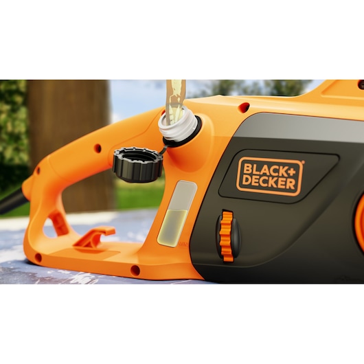 Photo de la tronçonneuse BLACK+DECKER BECS2040 remplissage d'huile, vue rapprochée sur la poignée et le bouchon.