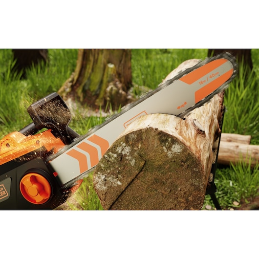 Tronçonneuse BLACKDECKER BECS2040 coupant une bûche en extérieur, gros plan sur le guide et la chaîne en action.