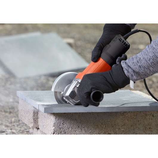 BLACKDECKER BEG110K haakse slijper snijdt steen, close-up buitenshuis fotografie.