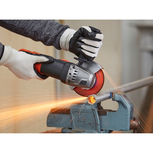 BLACKDECKER BEG220K haakse slijper in gebruik bij het zagen van een metalen buis, vonken, productfotografie.