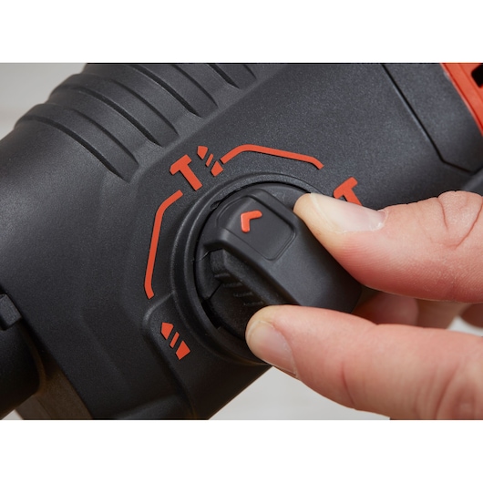 Sélecteur de mode du marteau perforateur BLACKDECKER BEHS01K en gros plan, marquages rouges, main ajustant le cadran.