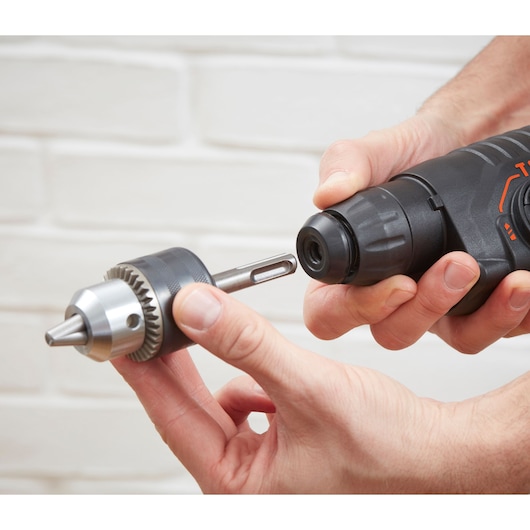Photo de la perceuse à percussion BLACKDECKER BEHS01K avec adaptateur mandrin sans clé en cours d'installation, vue rapprochée.