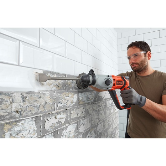 BLACKDECKER BEHS02K marteau perforateur retire des carreaux d’un mur, vue latérale, outil orange et gris.