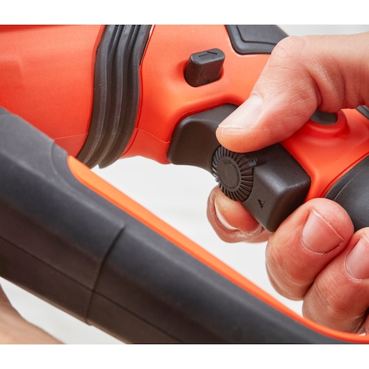 Photo en gros plan de la poignée de l’outil BLACKDECKER BEHS02K avec utilisateur ajustant le bouton rotatif noir, design orange et noir.