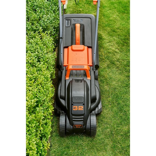 Photo de BLACKDECKER BEMW351 tondeuse sur l'herbe, vue supérieure du corps noir et orange et des roues.