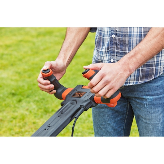 Foto van BLACK+DECKER BEMW461ES grasmaaier handgreep met ergonomische bediening buiten.