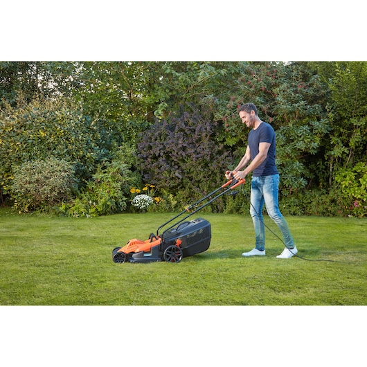 BLACKDECKER BEMW481BGL2 grasmaaier in gebruik op gras in een tuin.
