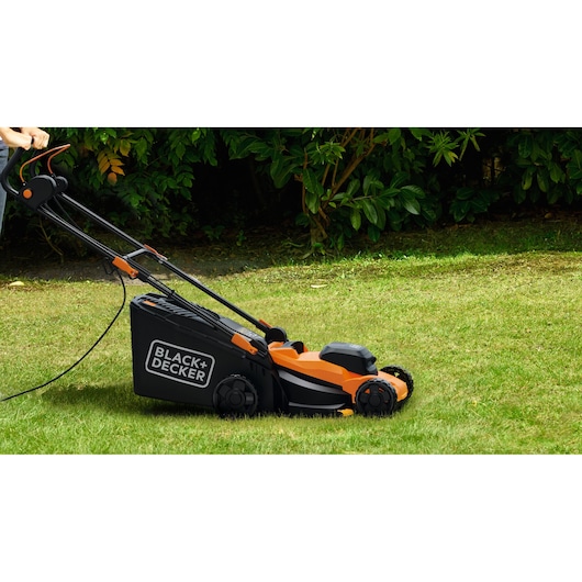 BLACK+DECKER BEMWP340-QS tondeuse électrique orange et noire sur gazon, vue latérale.