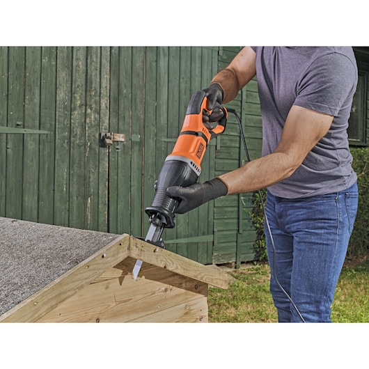 Foto van de BLACKDECKER BES301K reciprozaag in gebruik om hout buiten te zagen.