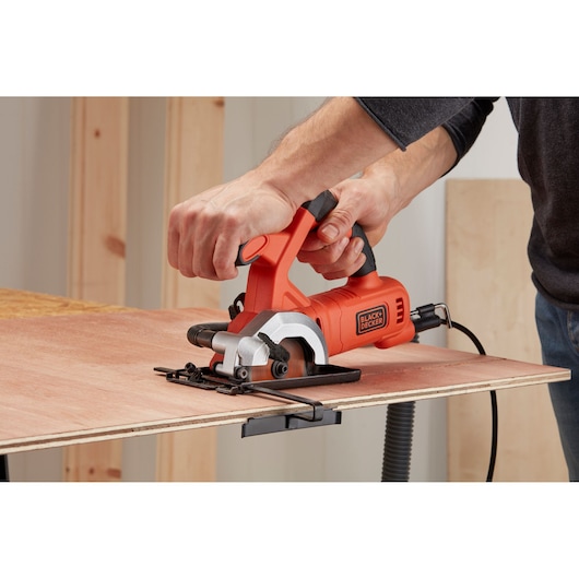 BLACK+DECKER BES510K compacte cirkelzaag snijdt multiplex, close-up in de hand.
