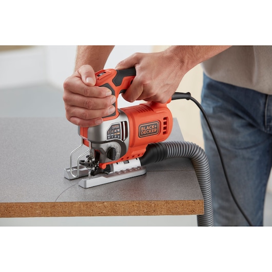 BLACKDECKER BES610K decoupeerzaag zaagt hout met stofafzuigslang, close-up fotografie.