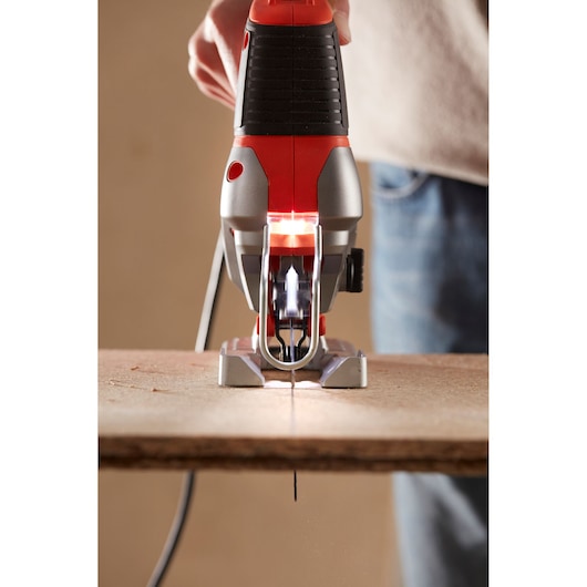 BLACKDECKER BES610 decoupeerzaag vooraanzicht zaagt houten plank, rood en zwart ontwerp.