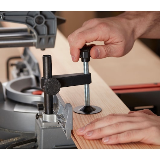 BLACKDECKER BES710 scie à onglets serrant une planche en bois, gros plan sur le mécanisme et les mains.