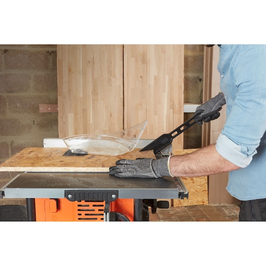 BLACKDECKER BES720 tafelzaag in gebruik, persoon met handschoenen zaagt houten paneel in werkplaats.