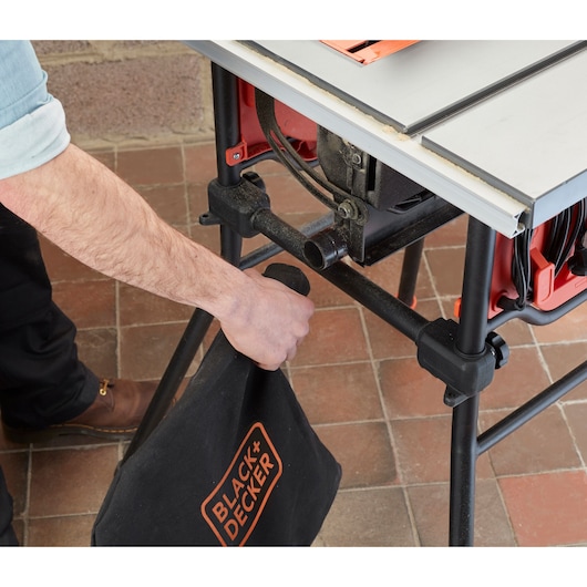 BLACK+DECKER BES720 tafelzaag met stofzakbevestiging wordt geplaatst, close-up zijaanzicht.