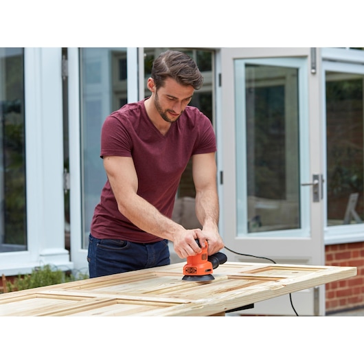 BLACKDECKER BEW200LSA schuurmachine gebruikt op houten deur buiten.