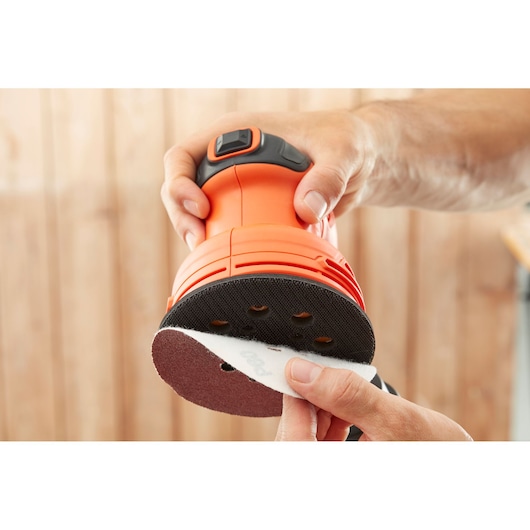 Foto van BLACKDECKER BEW210 excenterschuurmachine met schuurpad dat wordt bevestigd, close-up.