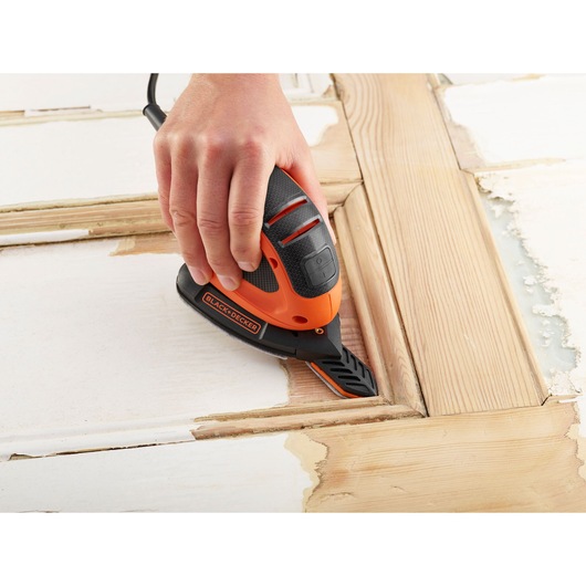Photo de ponceuse de détail BLACKDECKER BEW230BCA utilisée sur une surface en bois, outil tenu à la main.