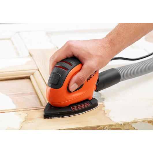 BLACKDECKER BEW230K ponceuse souris compacte orange ponçant une surface en bois, photo en gros plan