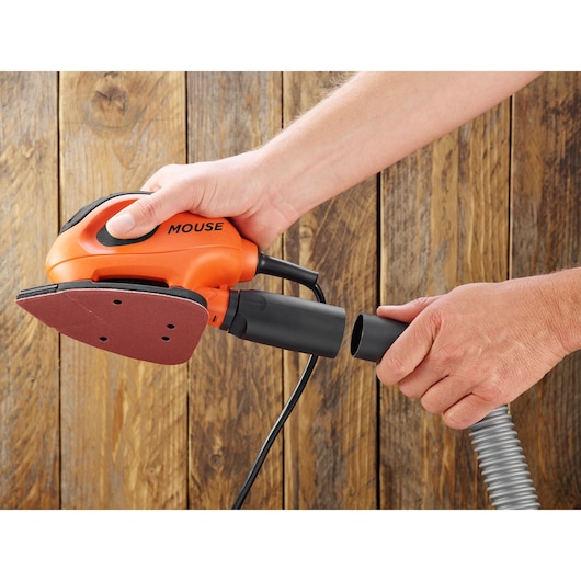 BLACKDECKER BEW230K ponceuse orange Mouse, câble et tuyau connectés, gros plan sur fond en bois.