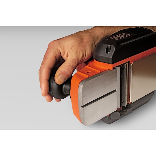 Vue rapprochée latérale du rabot électrique BLACK+DECKER BEW712 avec une main tenant la poignée avant noire.