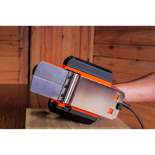 BLACKDECKER BEW712 ponceuse à bande électrique, noir et orange, sur surface en bois, vue latérale rapprochée.