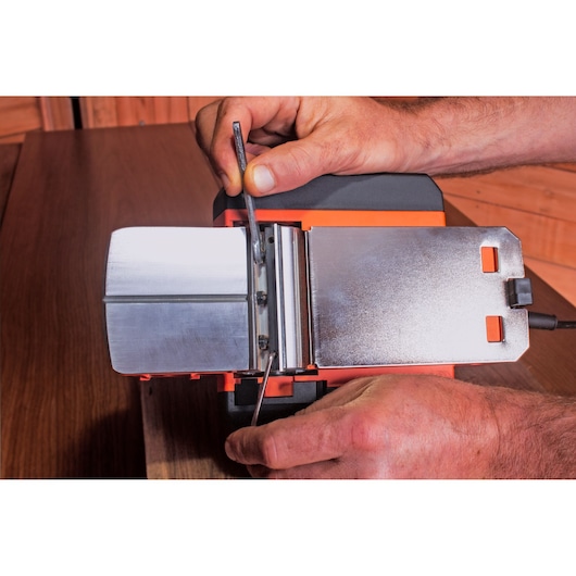 BLACKDECKER BEW712 outil électrique avec base métallique, gros plan lors du réglage sur une surface en bois.