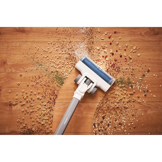 BLACKDECKER BHFEA420J aspirateur sans fil nettoyant des débris alimentaires sur sol en bois, vue de dessus.