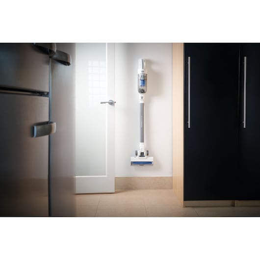 Aspirateur balai sans fil BLACKDECKER BHFEA420J fixé au mur dans une cuisine moderne.